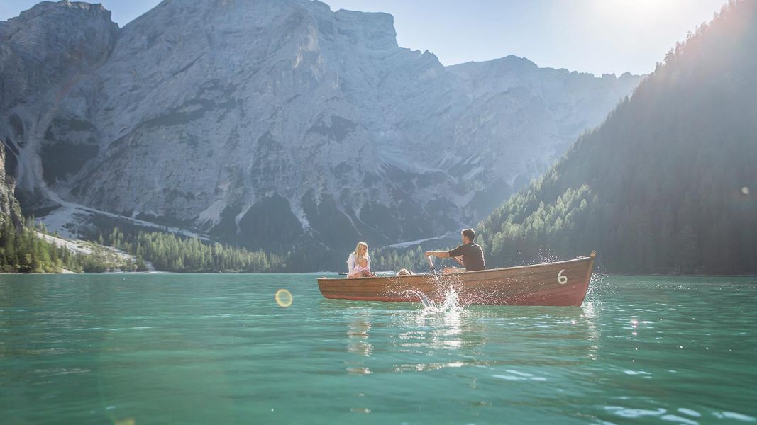 Coppia con bambina in barca sul Lago di Braies in una giornata soleggiata