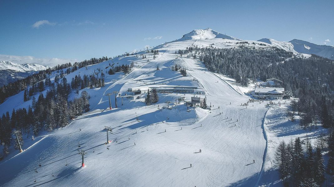 Panorama del comprensorio sciistico con piste ampie, impianti di risalita e cime innevate