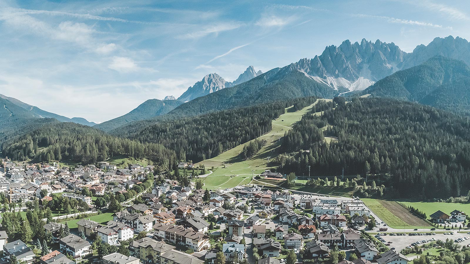 Blick auf die Stadt von oben, mit den bewaldeten Hügeln als malerischer Kulisse.